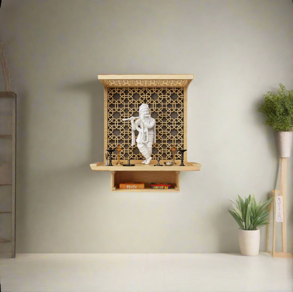 Modern wall-hanging wooden pooja mandir with jaali design and white Lord Krishna idol, placed against a light green wall with minimalist decor.