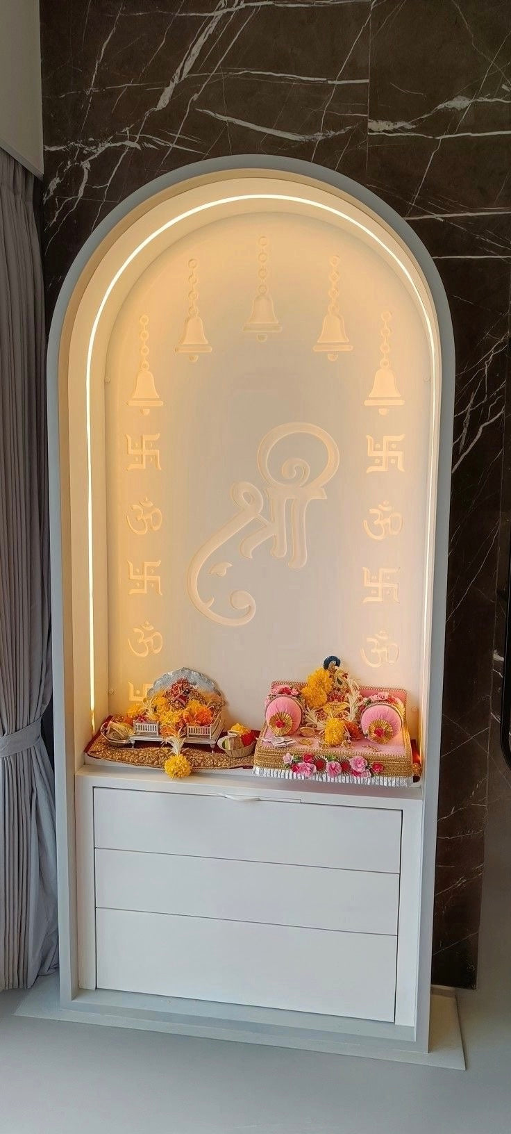 Minimalist Corian pooja mandir with LED backlit Shree panel, Om and Swastik engravings, and sleek white finish – wall-mounted Hindu temple for modern homes.