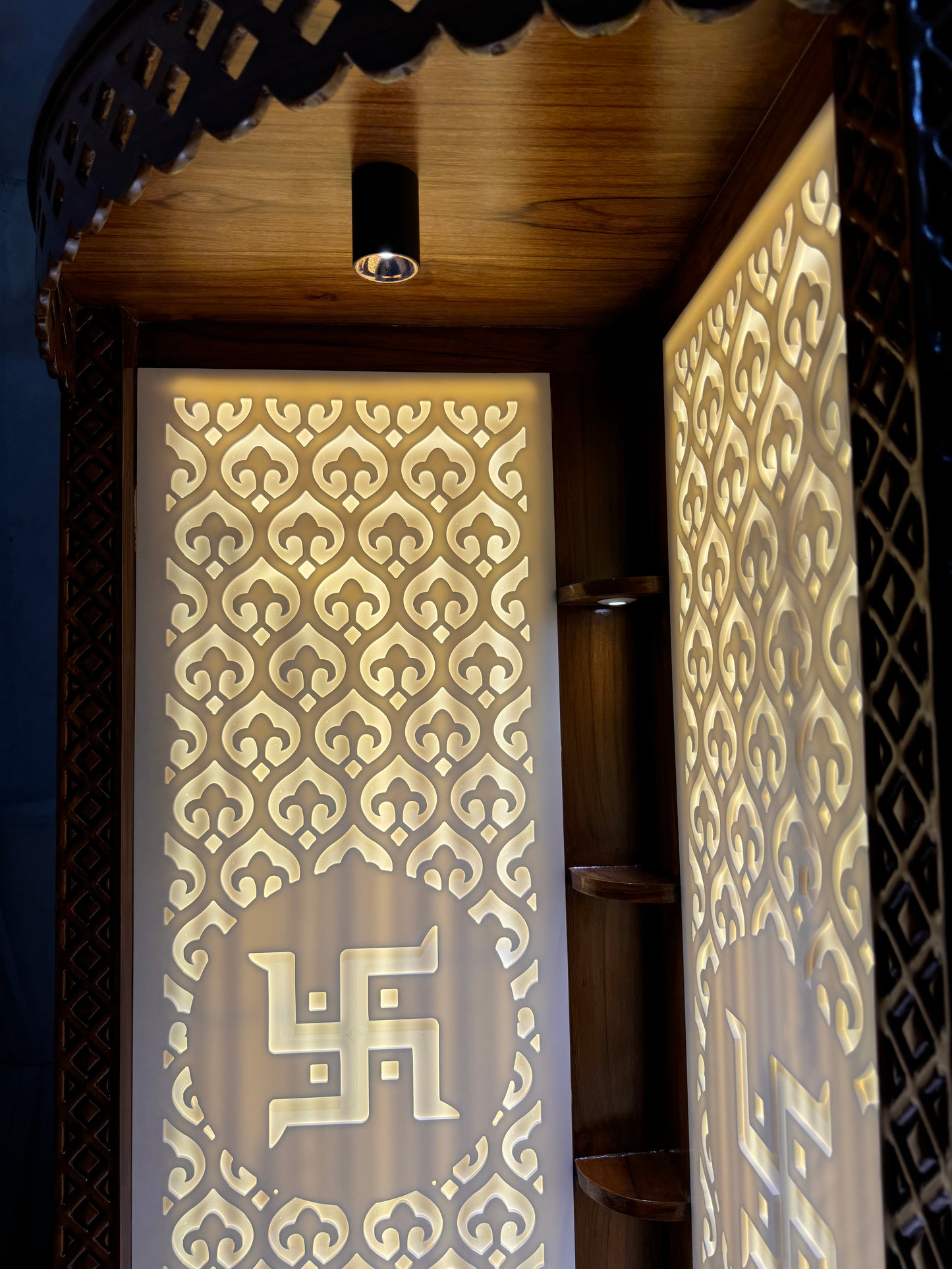 Elegant mandir in Corian and teakwood featuring illuminated religious motifs