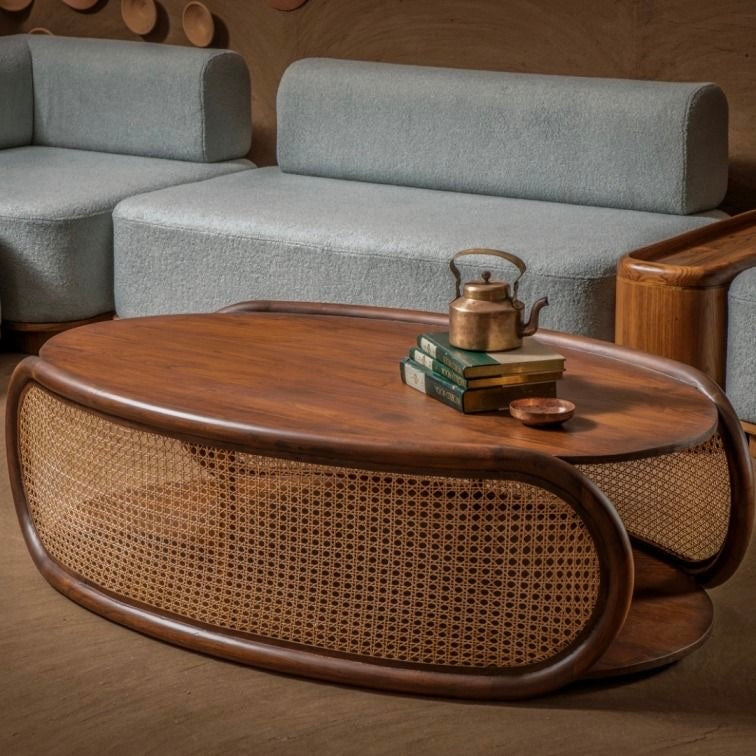 Handcrafted wooden coffee table with curved edges and woven rattan panels, featured in a cozy, modern living room setup with contemporary seating.