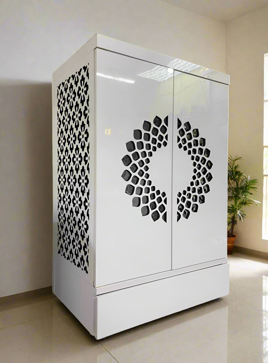 A beautifully designed wooden pooja mandir with intricate laser-cut floral patterns on the sides and a circular cutout design on the doors, finished in glossy white. Perfect for home prayer spaces.
