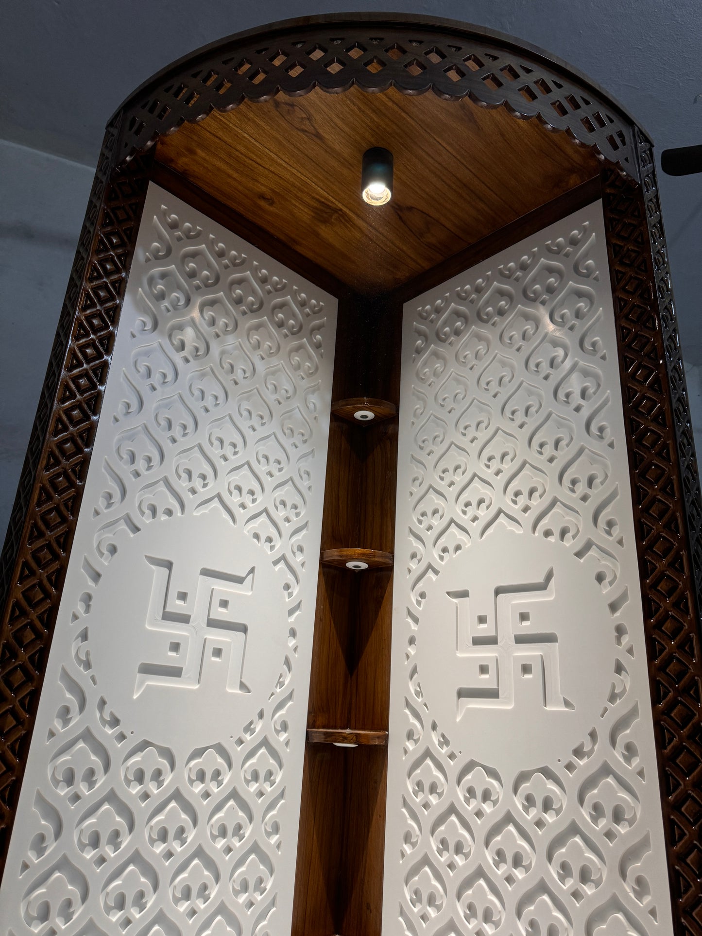 Space-efficient corner mandir unit in luxurious Corian and teakwood combination