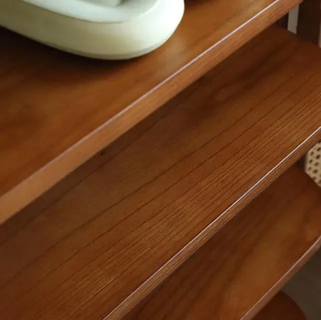 Elegant brown shoe rack placed in a minimal interior space with natural light and wall art.