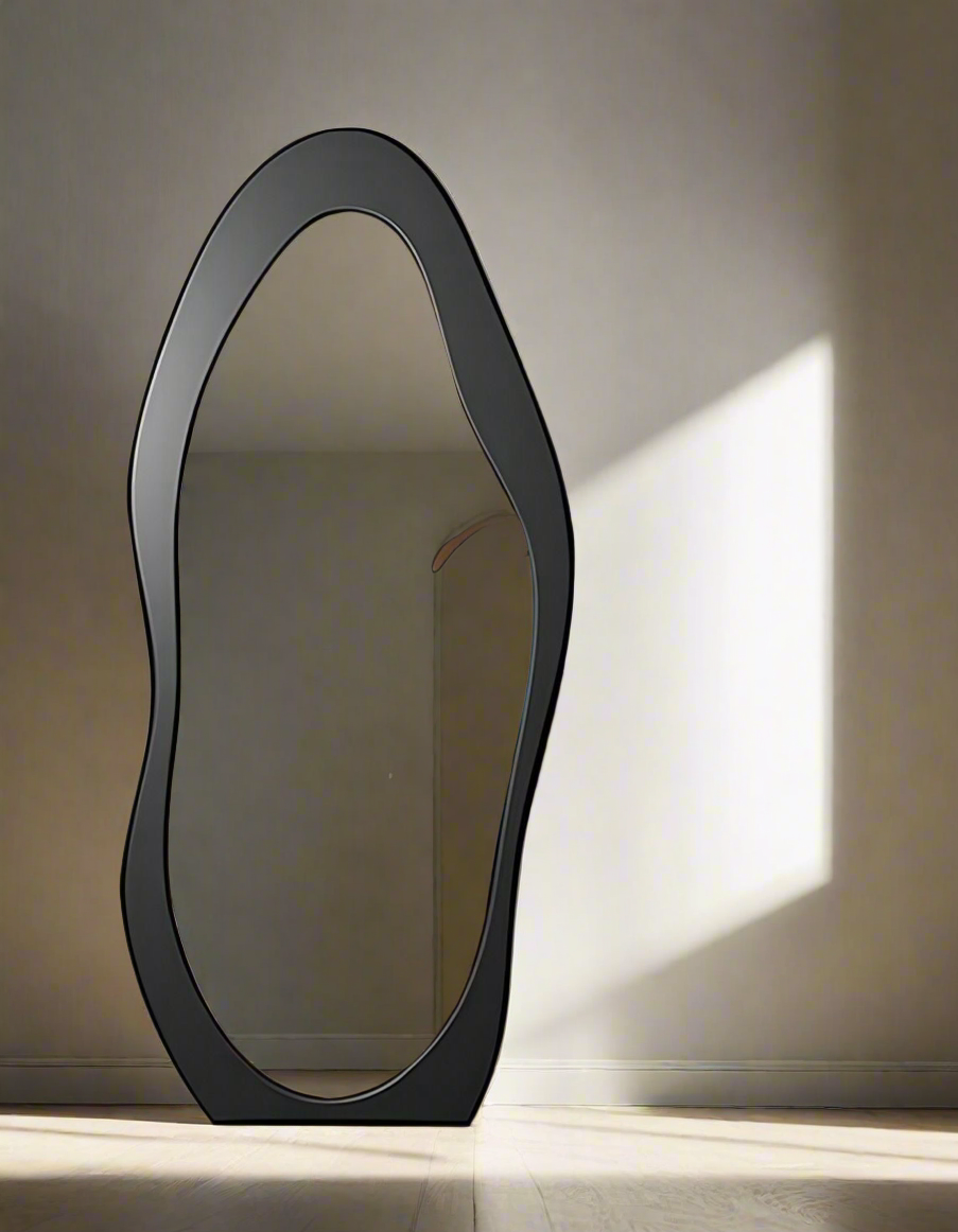 Contemporary full-length mirror with black abstract frame, placed in a stylish modern interior with light wooden flooring and neutral-toned furniture.