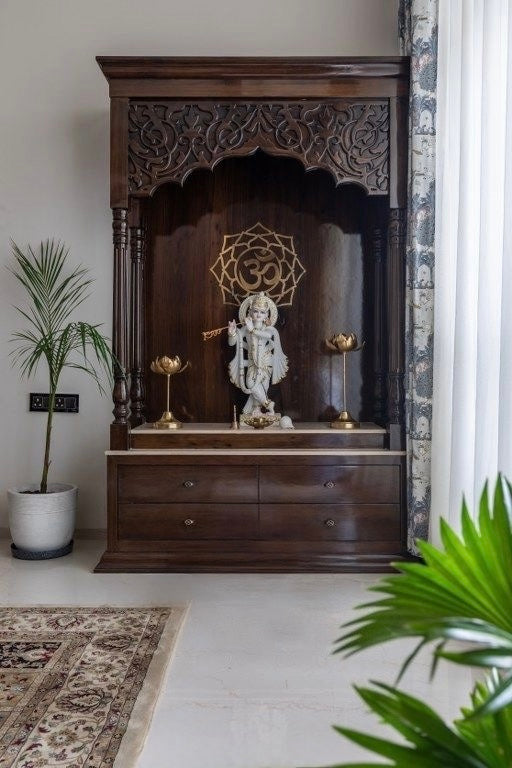 Luxurious handcrafted wooden pooja mandir with Lord Krishna idol, carved arch detailing, brass lotus lamps, and Om symbol centerpiece—perfect for modern spiritual interiors.