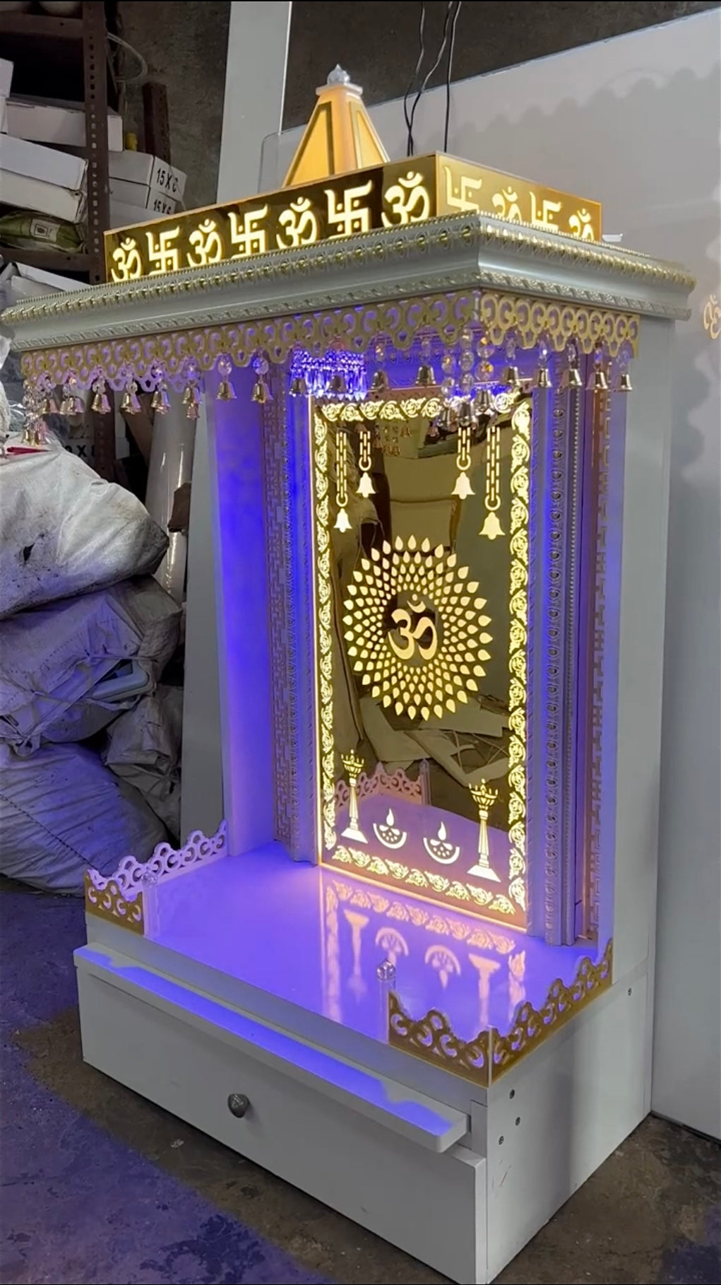 Modern luxury home temple with golden mirror back panel, LED lights, and storage drawer