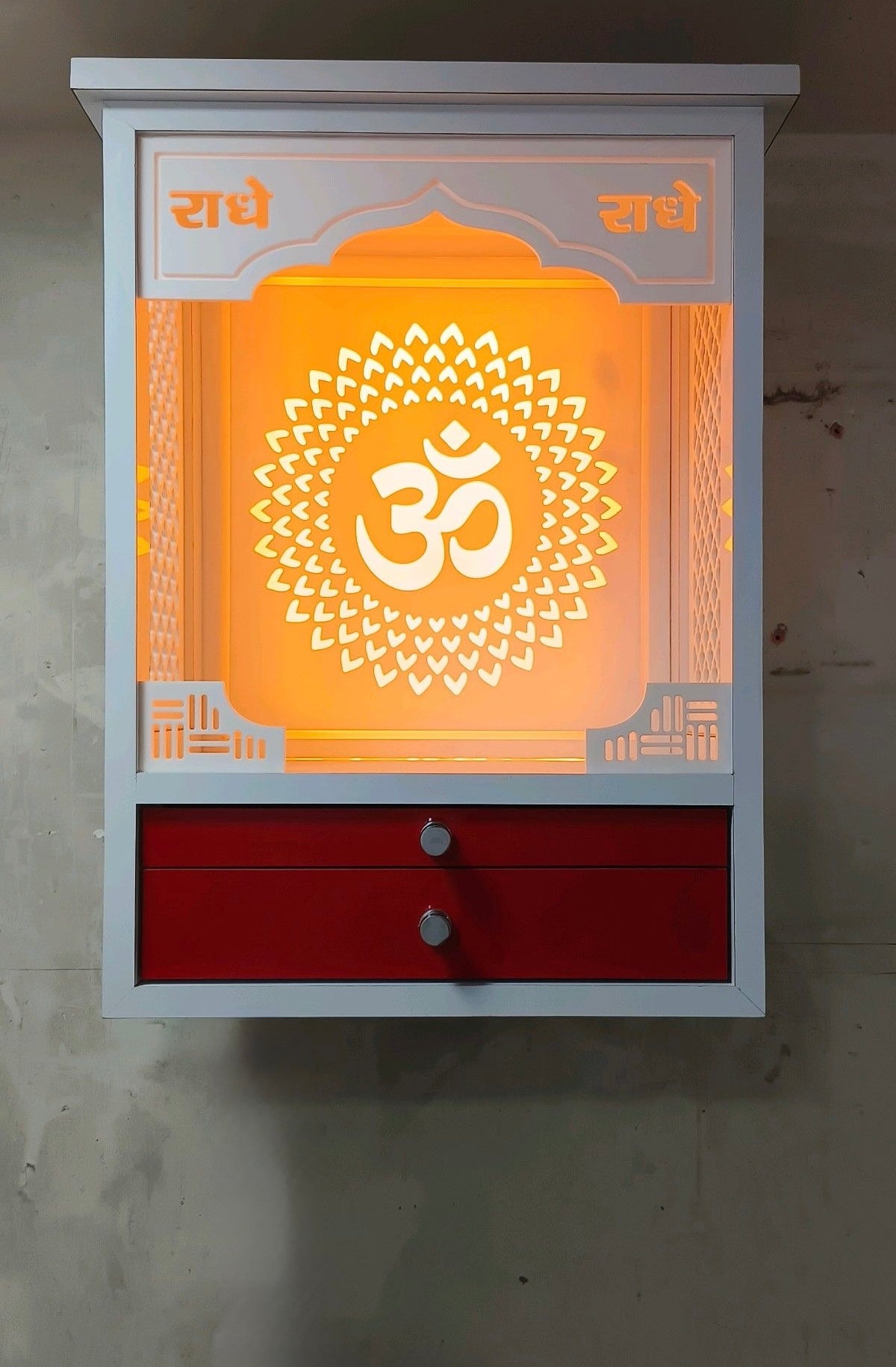 This stylish prayer unit features a minimalist Corian structure, bold red accents, and a luminous Om cutout for a peaceful aura.