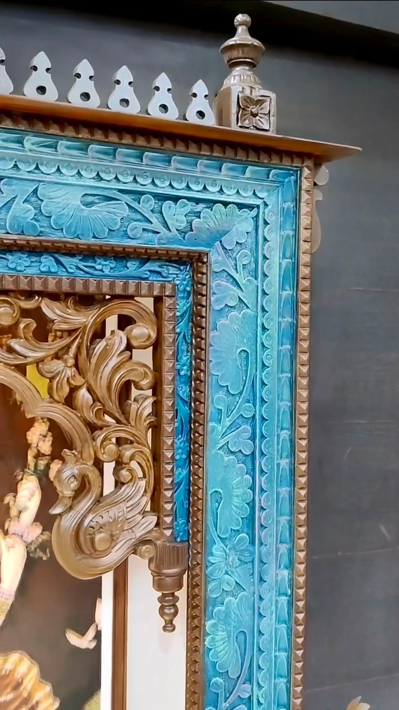 Traditional large wooden pooja mandir with detailed drawer carvings, a rich dark brown finish, peacock-themed accents, and a stunning Corian Radhe Krishna artwork.