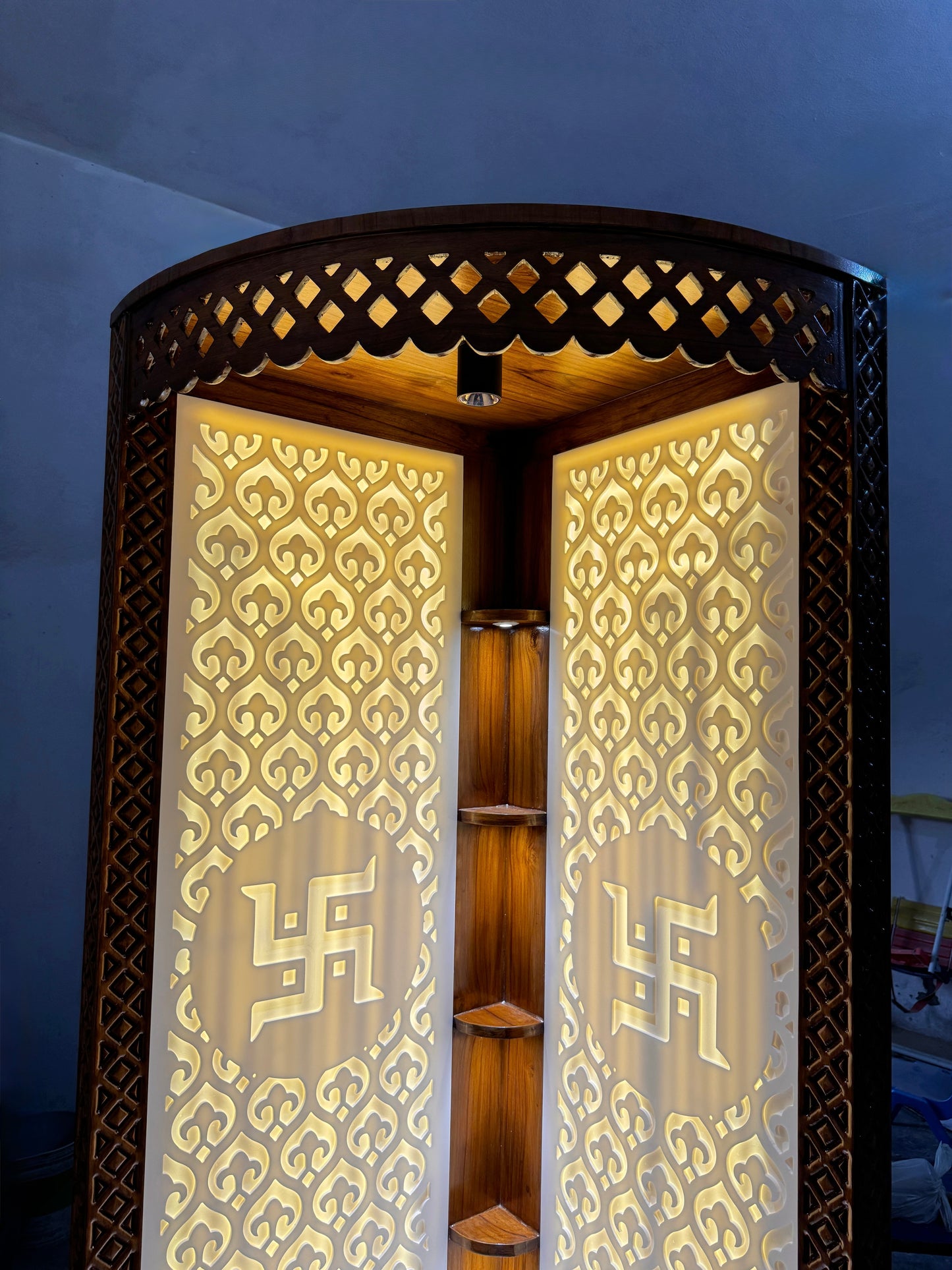 Luxury pooja unit in white Corian and teakwood with spiritual symbol backlighting