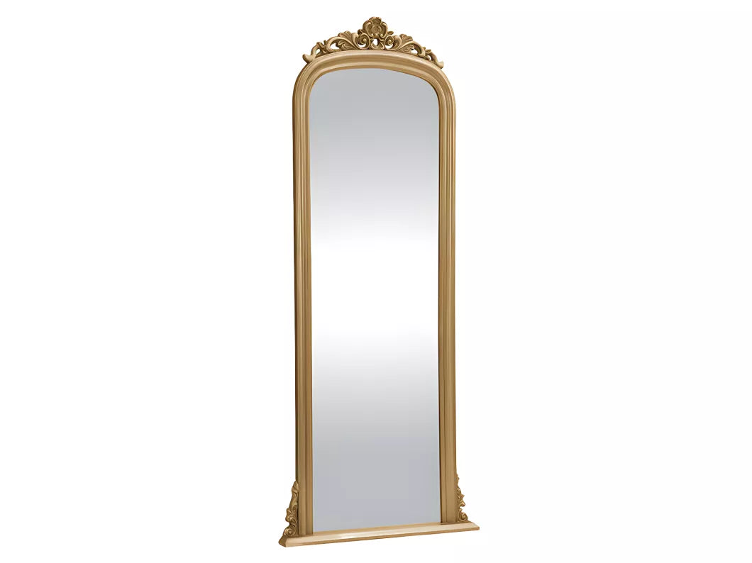 Tall antique gold mirror with ornate crown molding, standing against a light grey wall with contemporary decor.