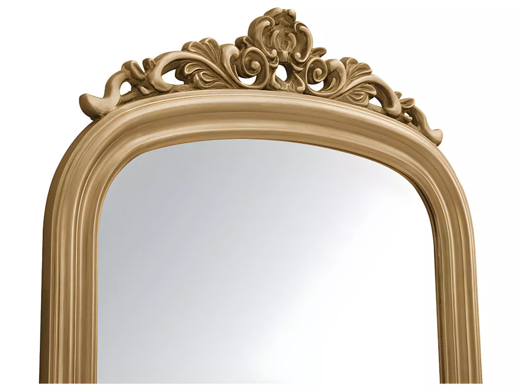 Luxurious gold framed leaning mirror featuring intricate scrollwork design, perfect for bedroom or dressing area styling.