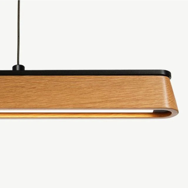 Close-up view of modern teak wood linear LED pendant light with warm glow