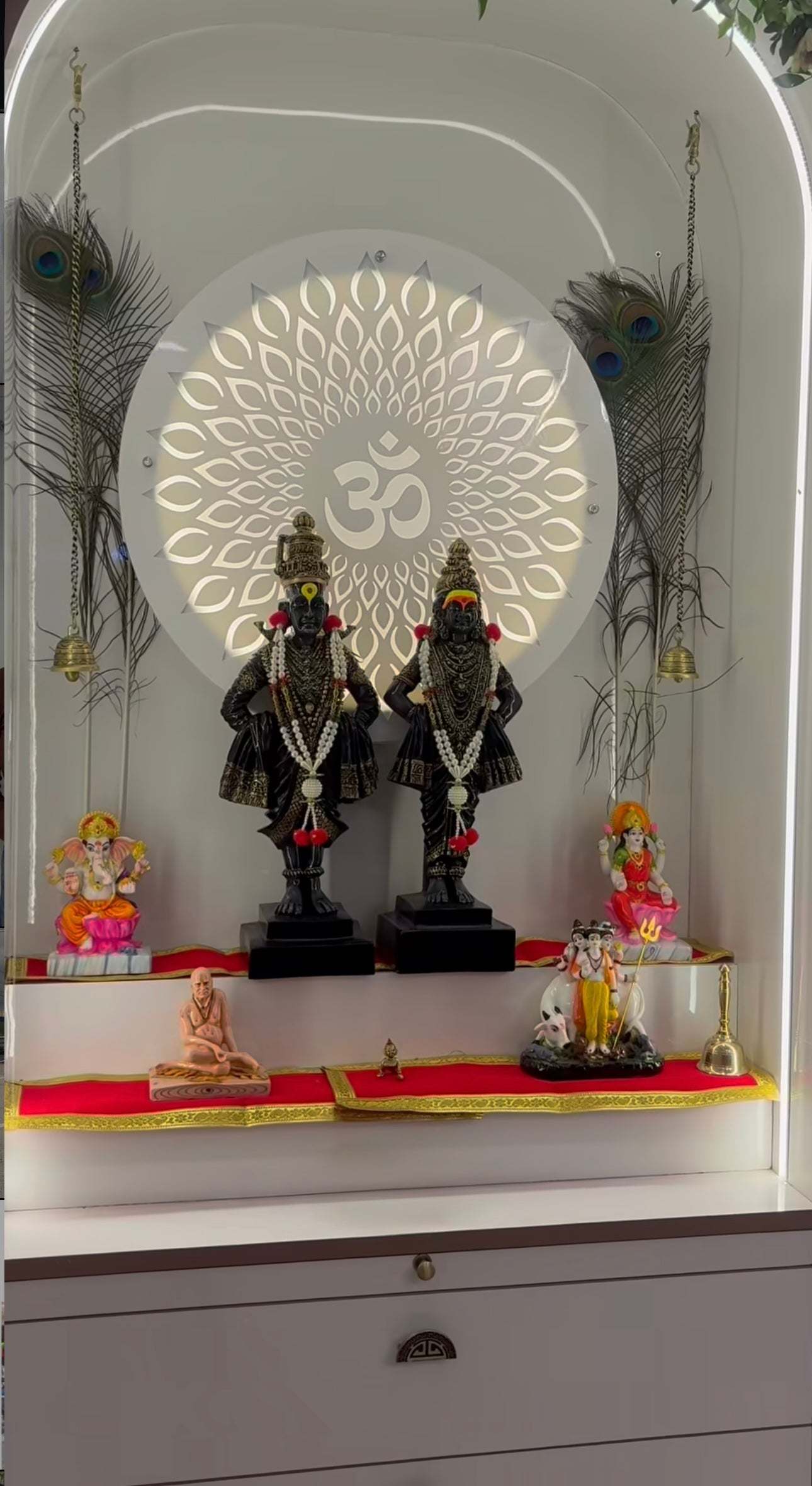 Premium corner mandir with Vithoba-Rukmini statues, floral garland, and ambient lighting for modern spiritual interiors.