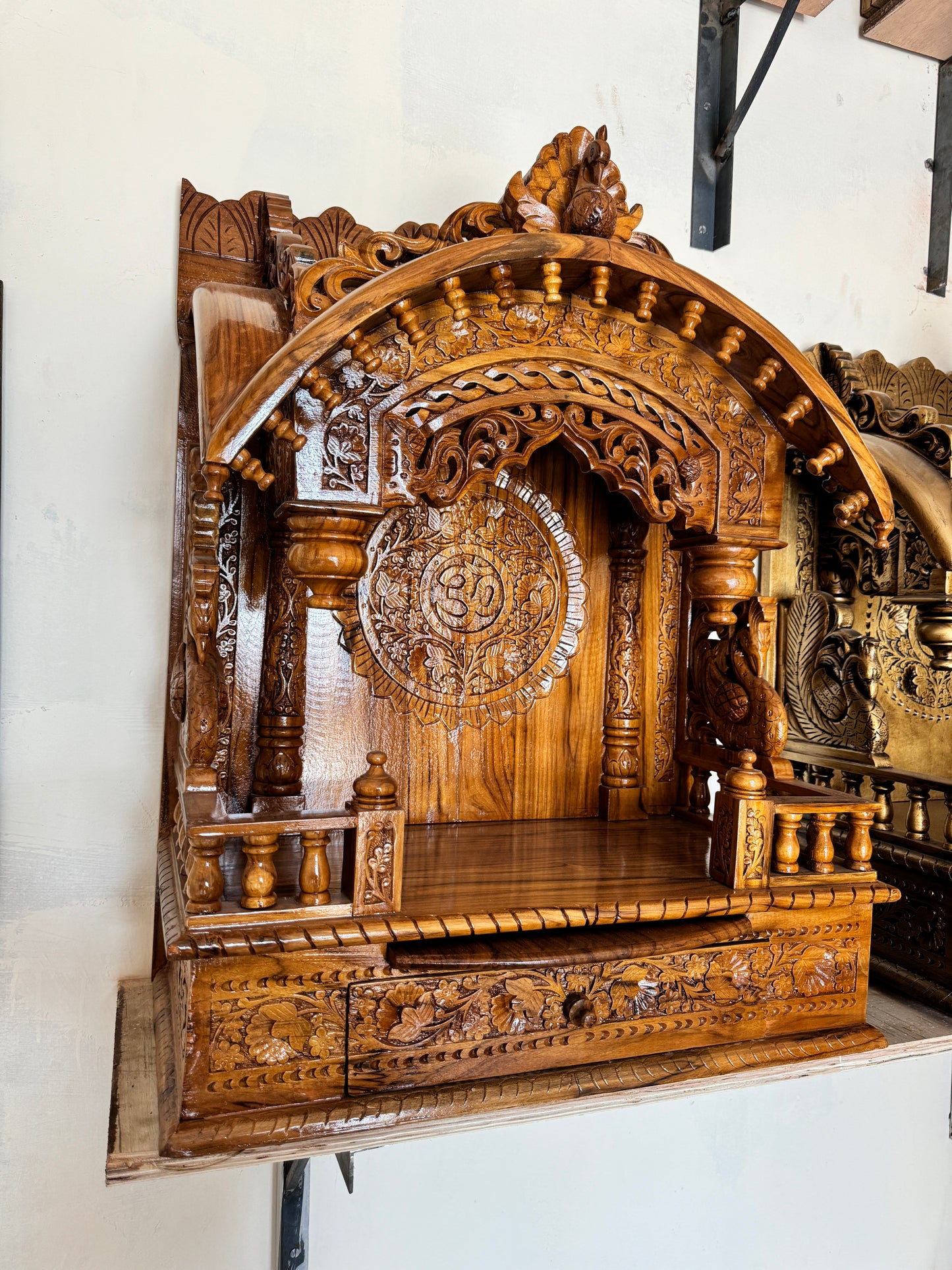 Decorative wooden home temple handcrafted with detailed latticework and cultural symbolism for puja rooms.