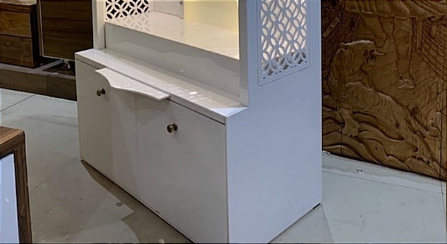 A well-designed home temple with an extended drawer space, cabinet storage, and intricate lattice paneling for a divine ambiance.