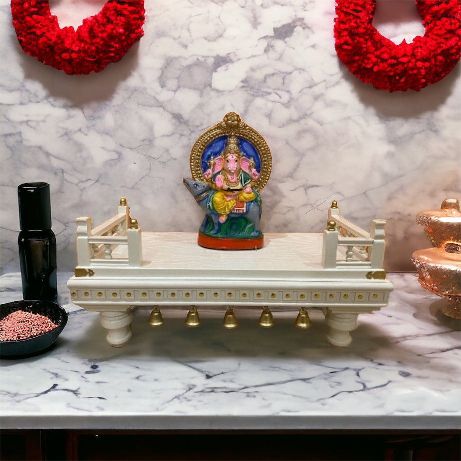 Ornate Hindu puja table in white and gold, featuring a raised platform with intricate woodwork, ideal for placing idols, lamps, and religious essentials.