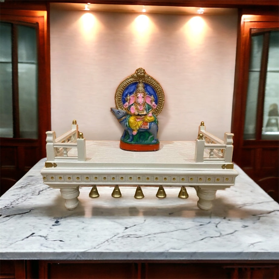 Intricately handcrafted white wooden puja chowki with gold accents and decorative bells, designed for home temples, religious ceremonies, and sacred worship.