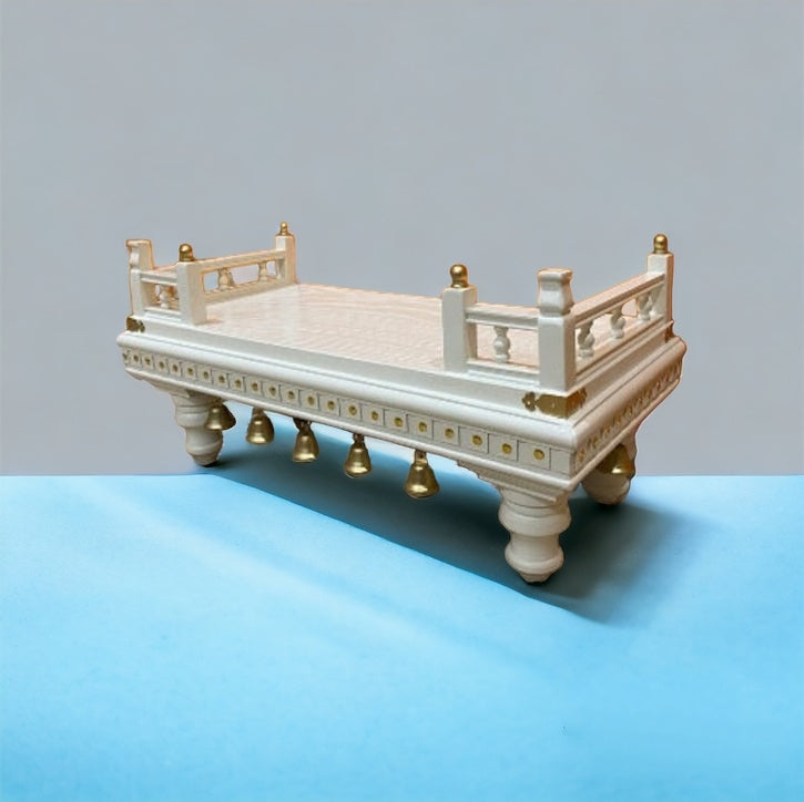 Elegant white wooden puja chowki with gold accents, decorative railings, and hanging bells – perfect for home temple decor and traditional rituals.