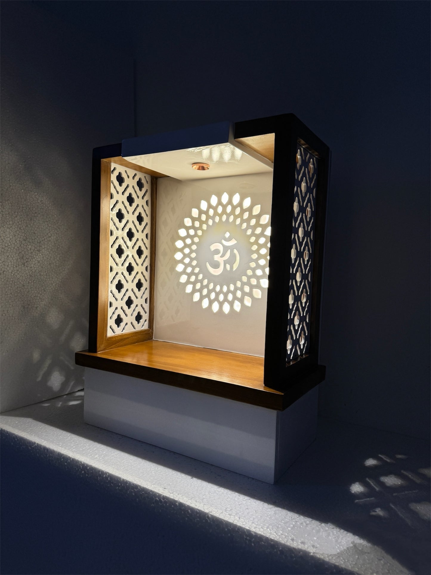 Exquisitely designed wooden pooja mandir with a spacious drawer, backlit Om symbol, and ornate lattice patterns. A divine addition to your prayer space.