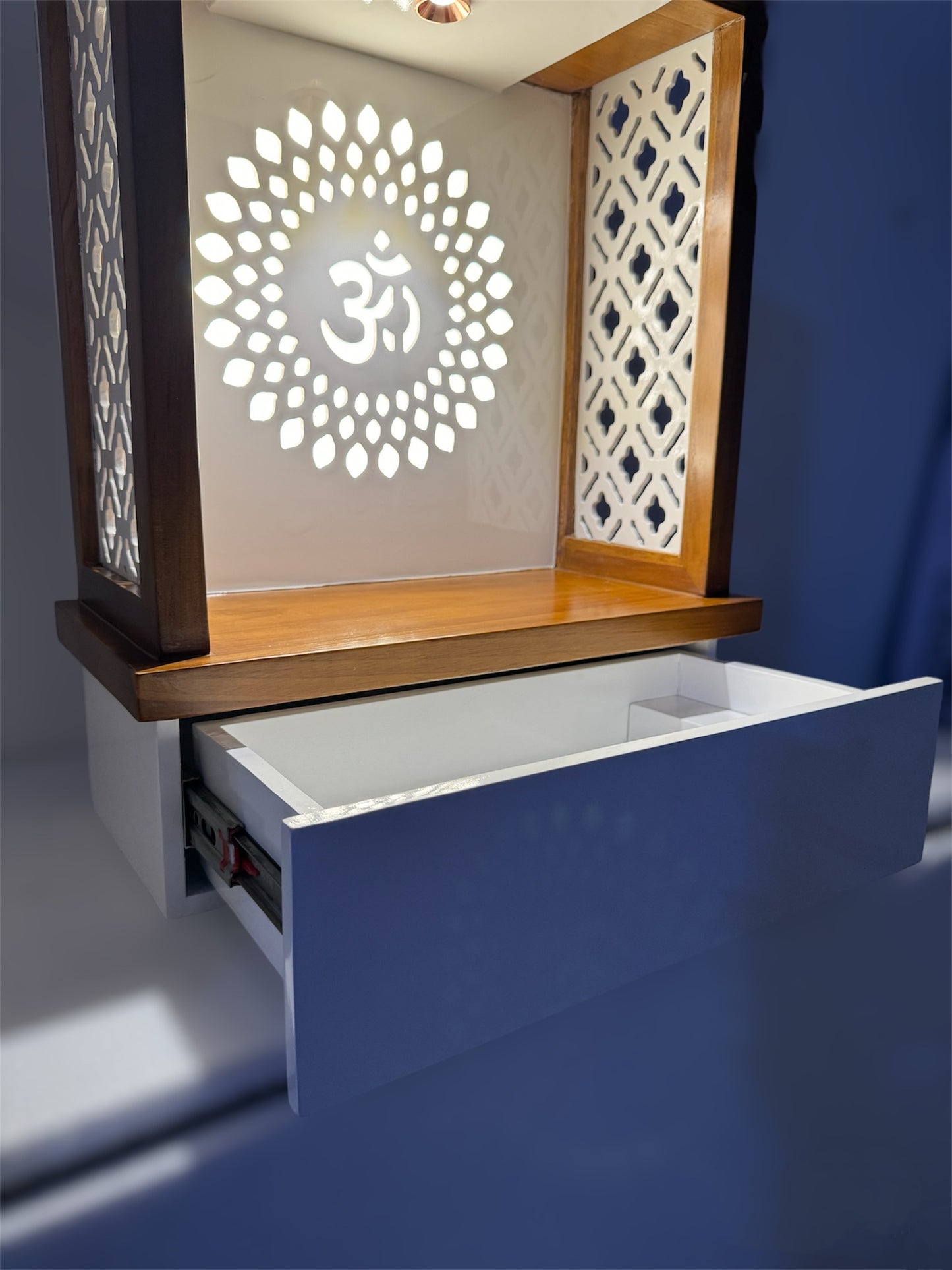 Beautifully designed wooden mandir with white and wood dual tones, drawer for storage, and ambient LED lighting for a divine home altar setup.
