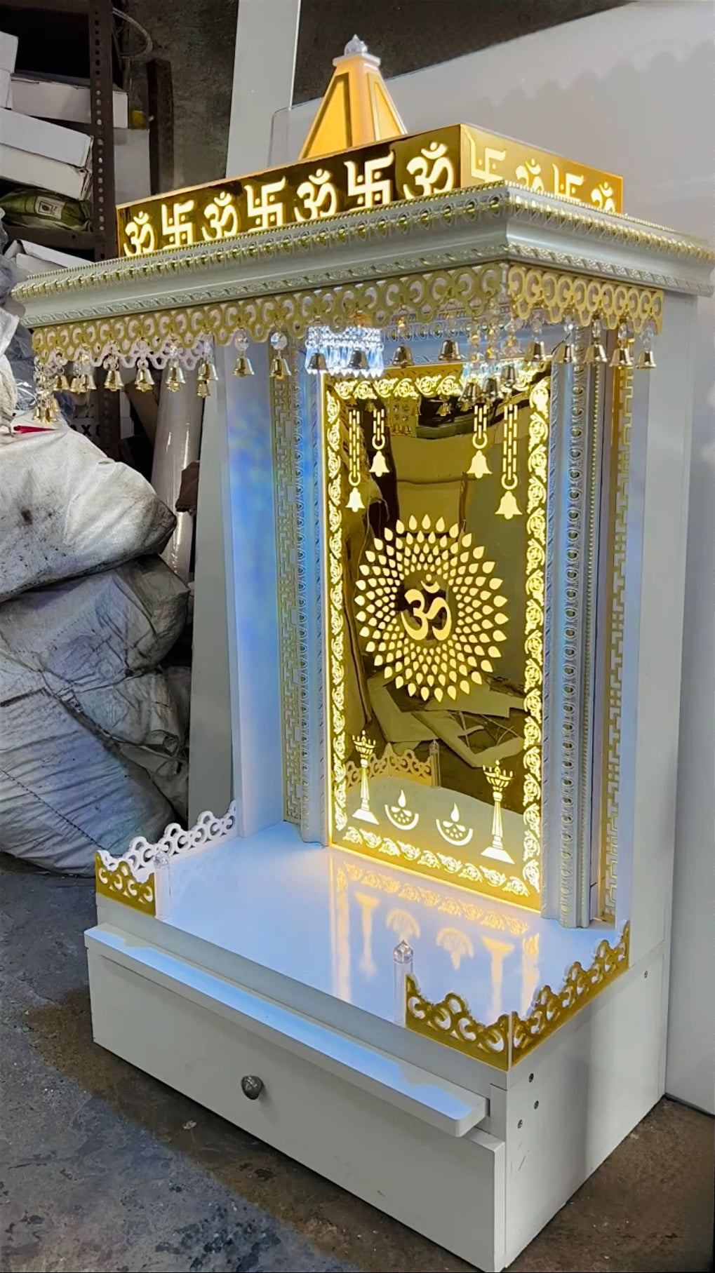 Handcrafted home temple with golden carvings and Golden illuminated Om panel