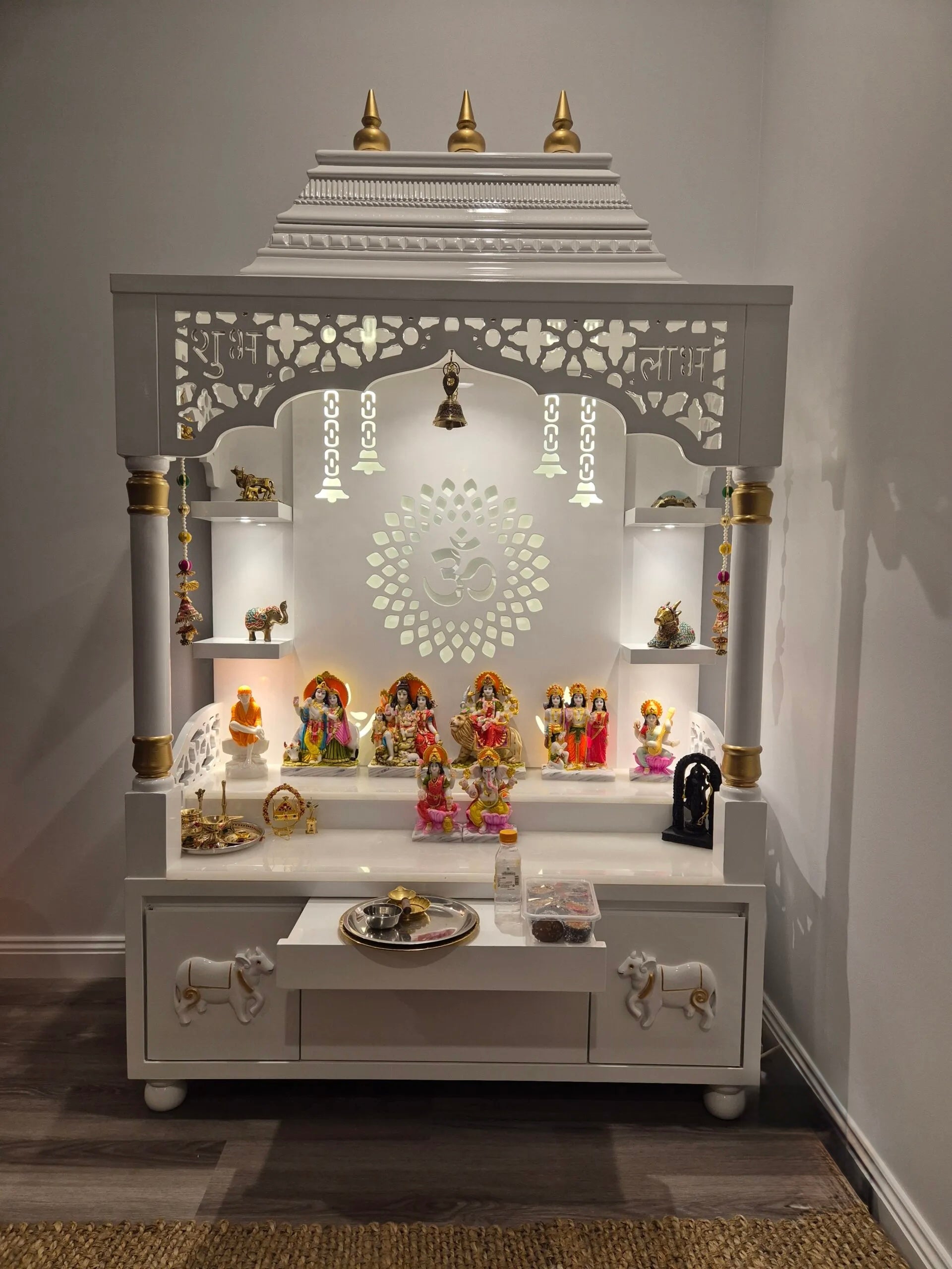 Handcrafted white wooden pooja mandir with LED lighting and intricate floral carvings for home temple decor