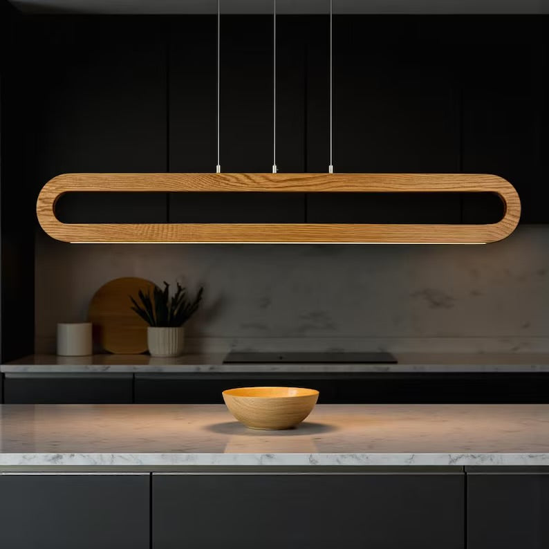 Modern kitchen with a long wooden pendant light fixture.