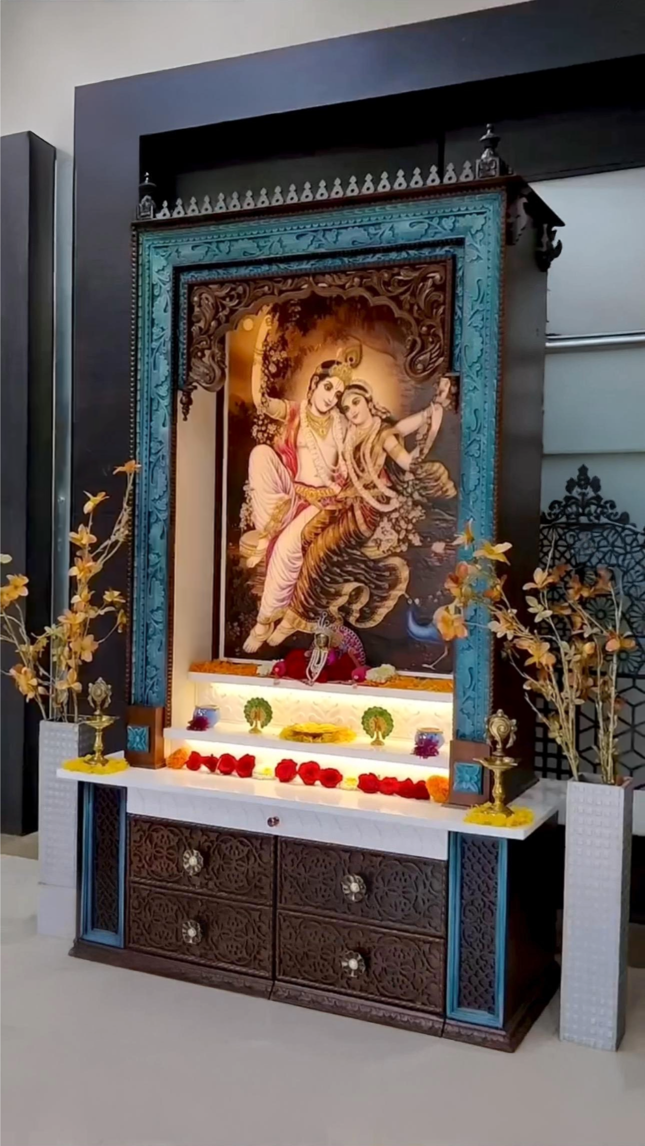 Handcrafted large pooja mandir in dark brown with peacock accents, featuring an elegant Corian Radhe Krishna picture and sophisticated drawer carving design.