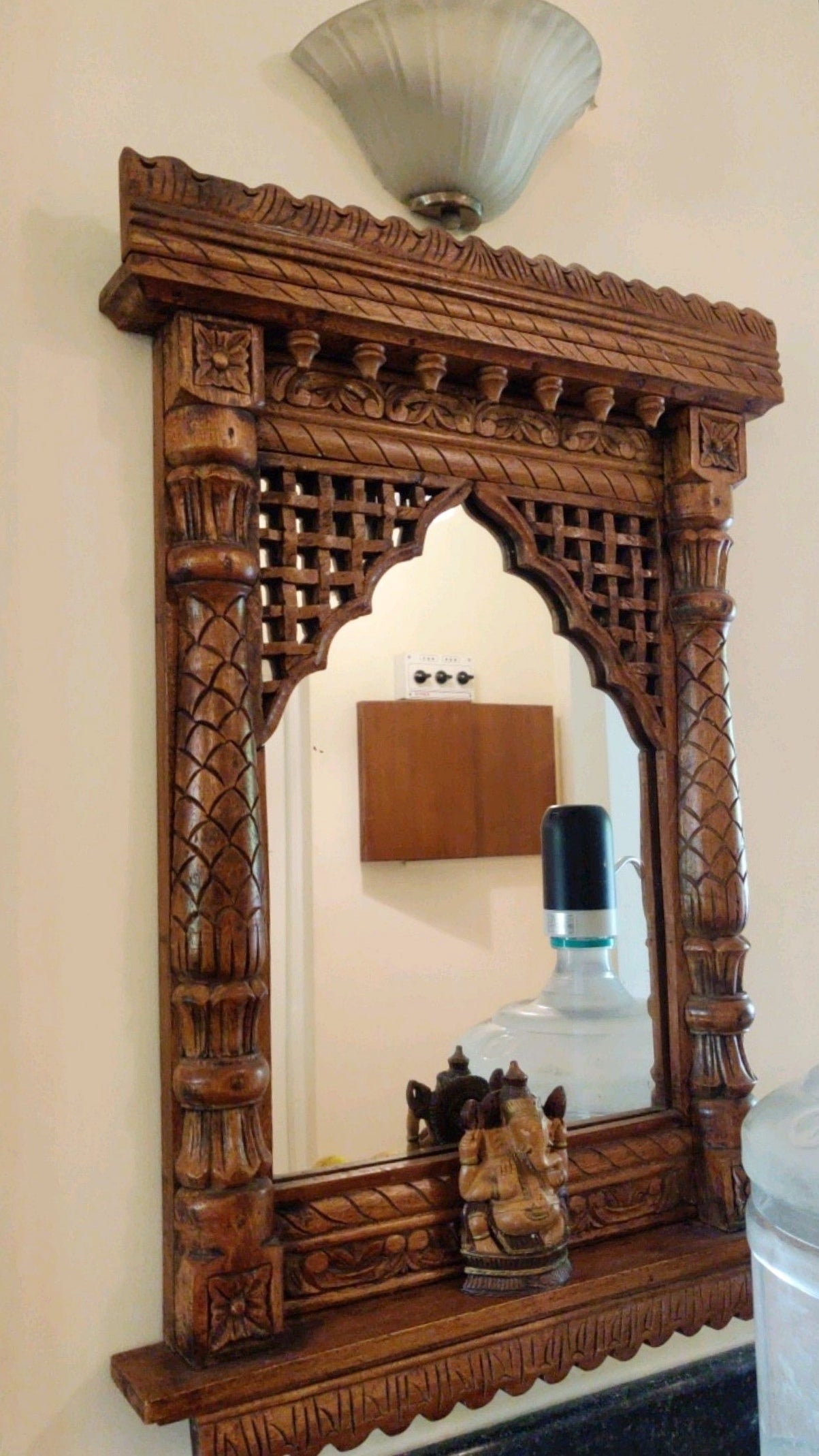 Rustic antique-style wooden Jharokha mirror with intricate lattice work and Ganesh idol – Rajasthani wall decor.