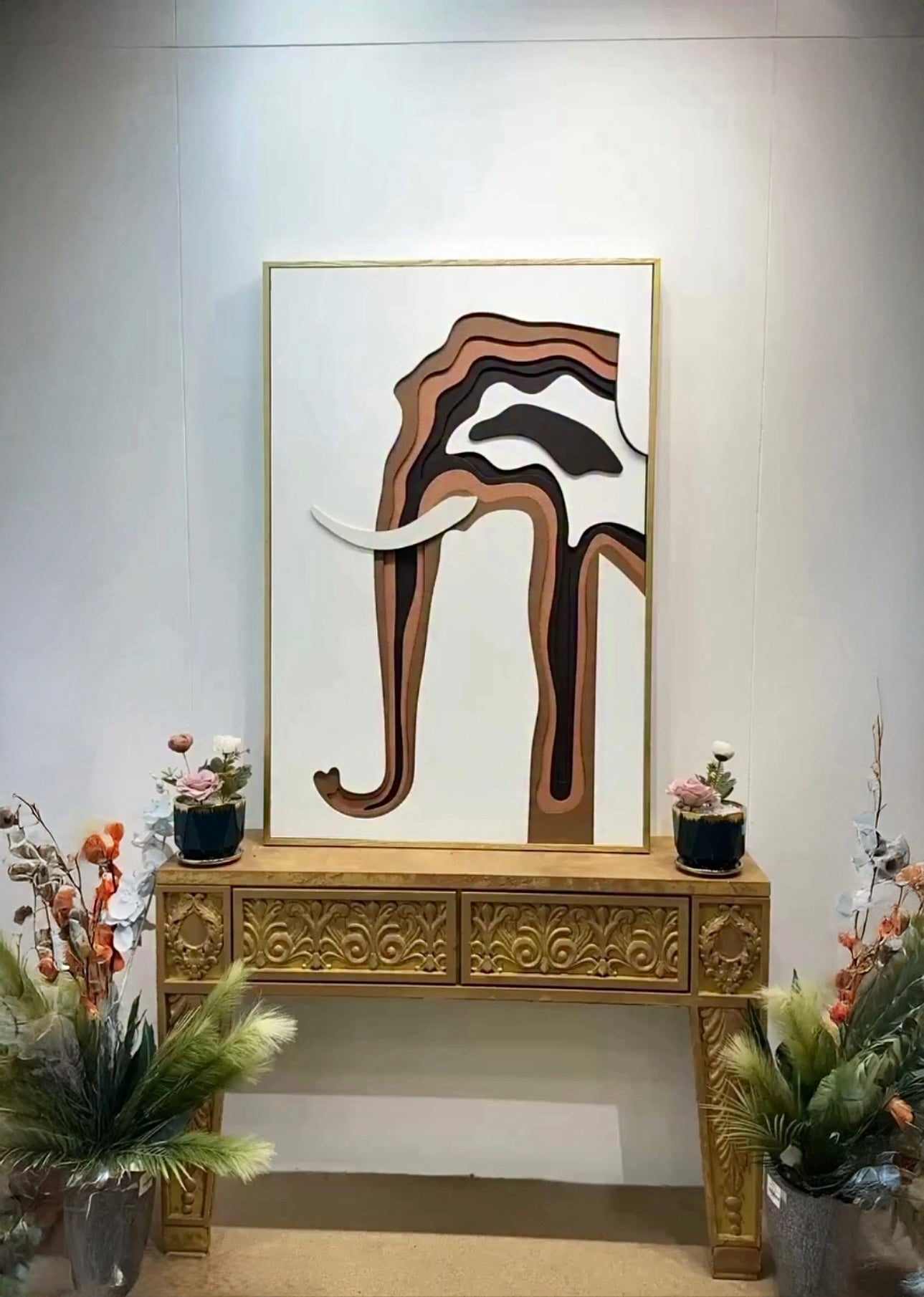 Handcrafted 3D layered elephant wall art in gold frame placed on carved wooden console table