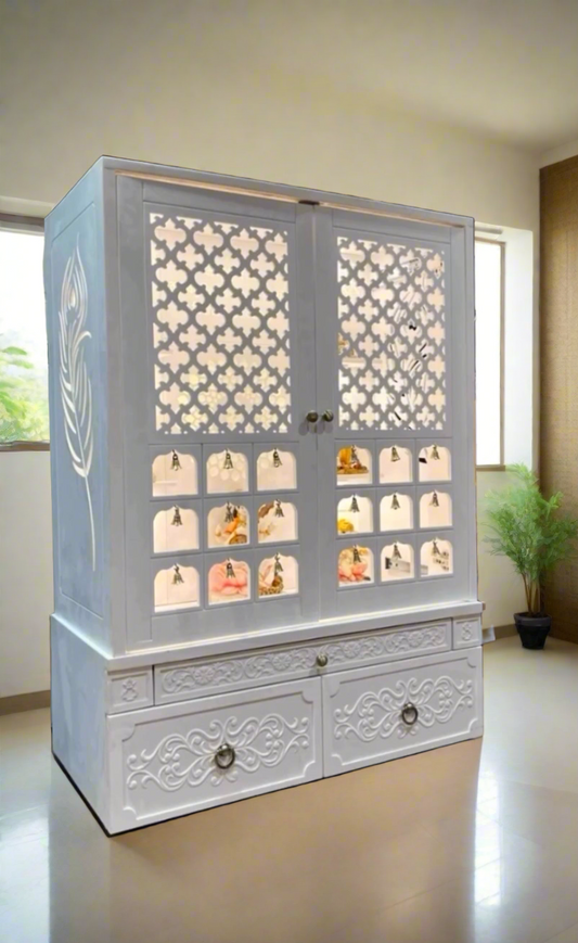 Luxurious white wooden home temple with LED lighting, intricate floral carvings, brass bell accents, and spacious platform housing idols of Ganesh, Lakshmi, and Krishna, ideal for a peaceful prayer corner.