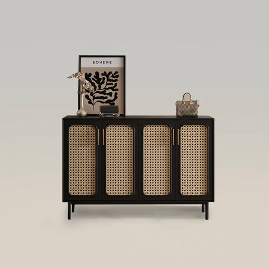 Modern black cane shoe cabinet with four rattan doors, decorated with vases, a framed artwork, and a handbag on top.