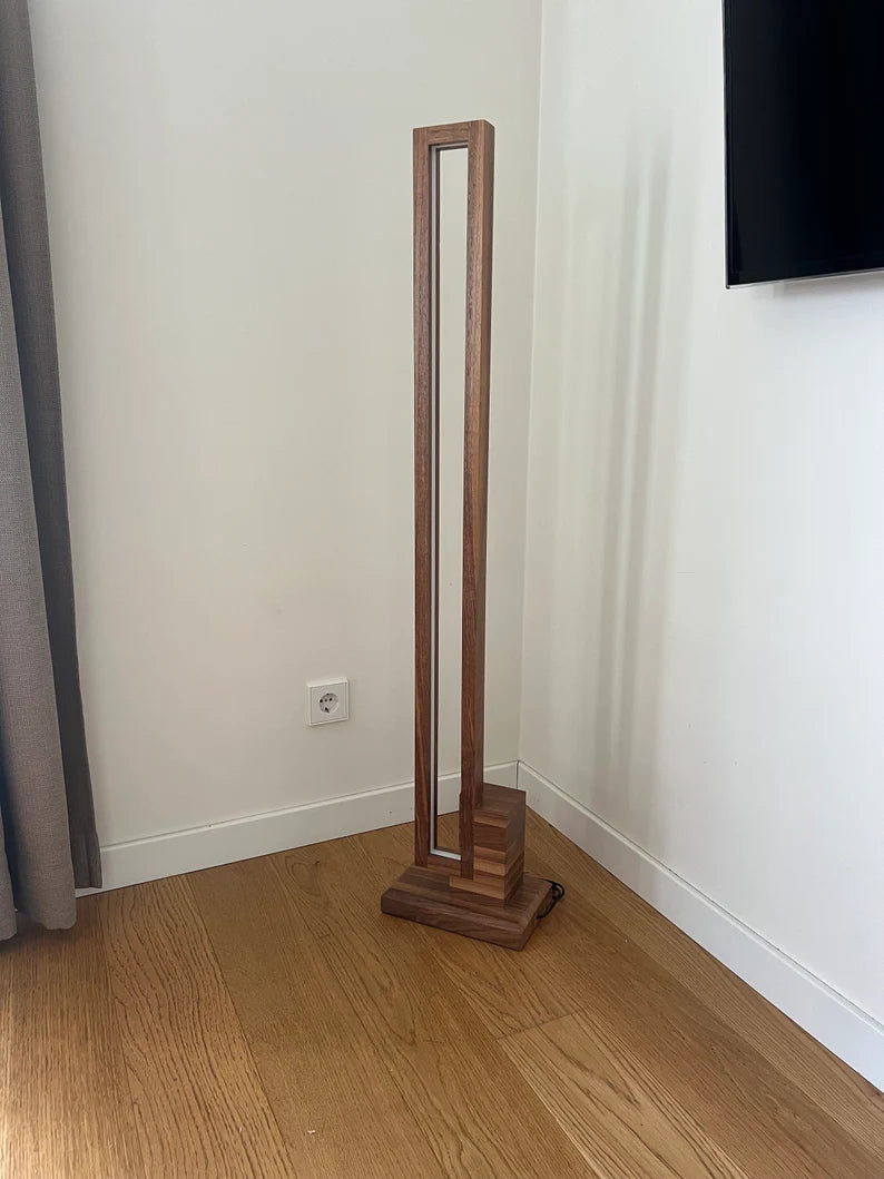 Wooden floor lamp on a wooden floor with a white wall background