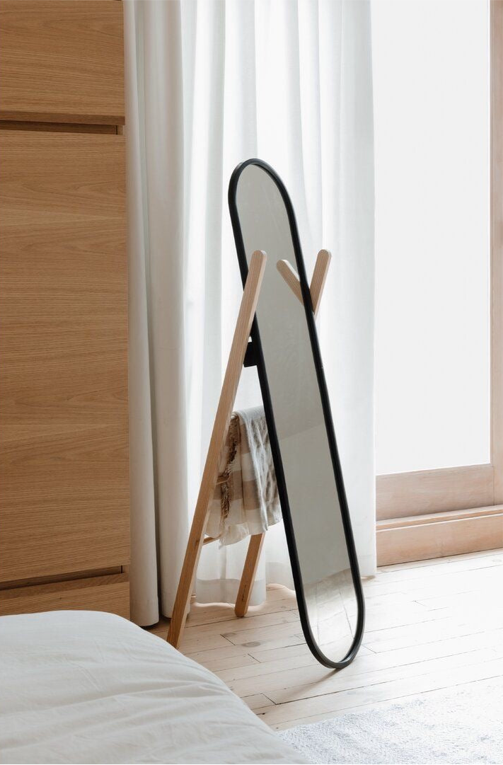 Modern black oval full length standing mirror with wooden frame and storage rack