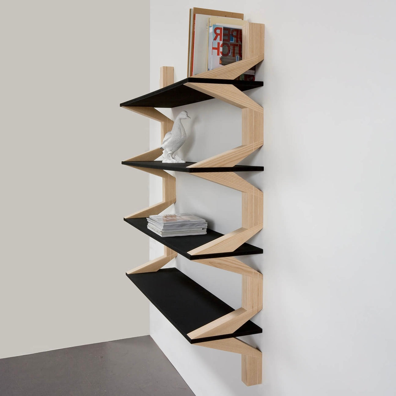 A modern, floating shelving system with bold black surfaces and an angular wooden frame.
