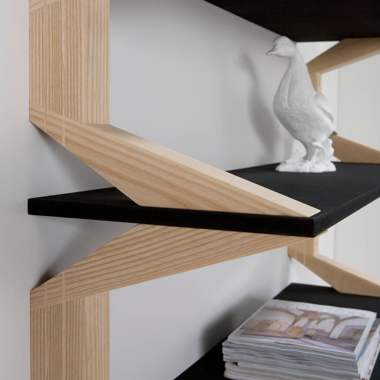 A detailed shot of the intersecting wooden supports and sleek black shelving.