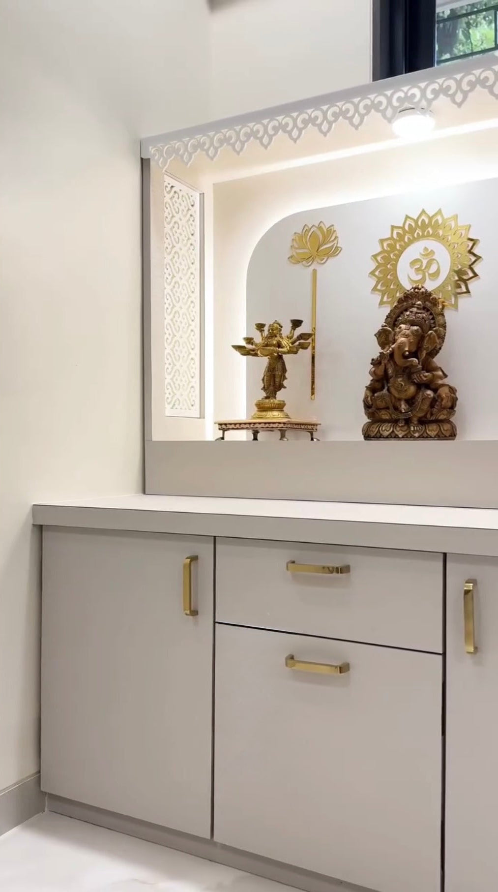 Modern white pooja mandir with LED backlight, CNC side panels, and storage cabinet.
