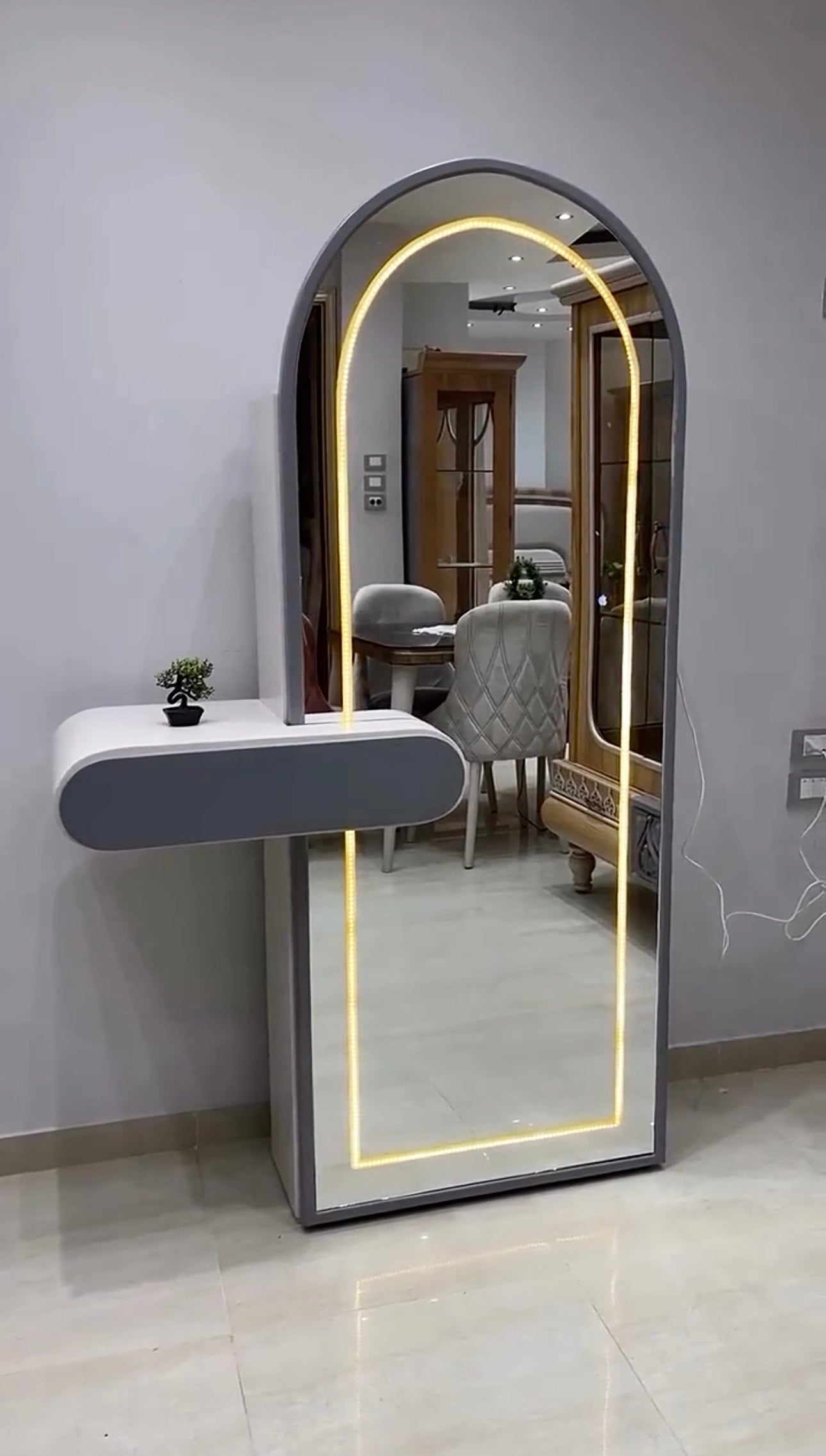 Contemporary full-length dressing mirror with warm light and side shelf