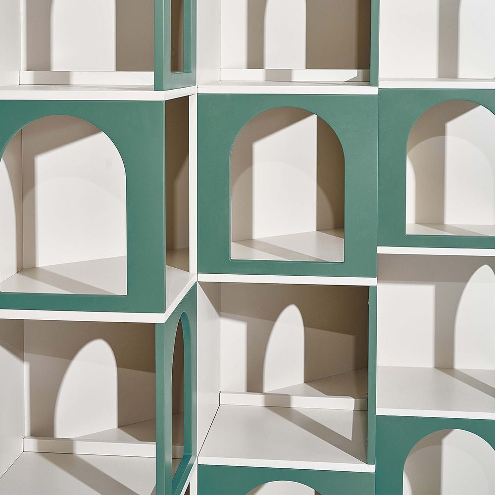 Close-up view of modular bookshelf showing green arched panels and white interior, with geometric shadows creating a dramatic visual effect.