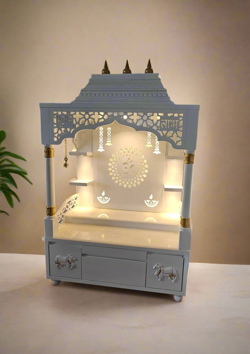 Elegant white wooden home temple with LED lights, Indian pooja mandir decorated with Hindu gods idols and traditional pooja setup
