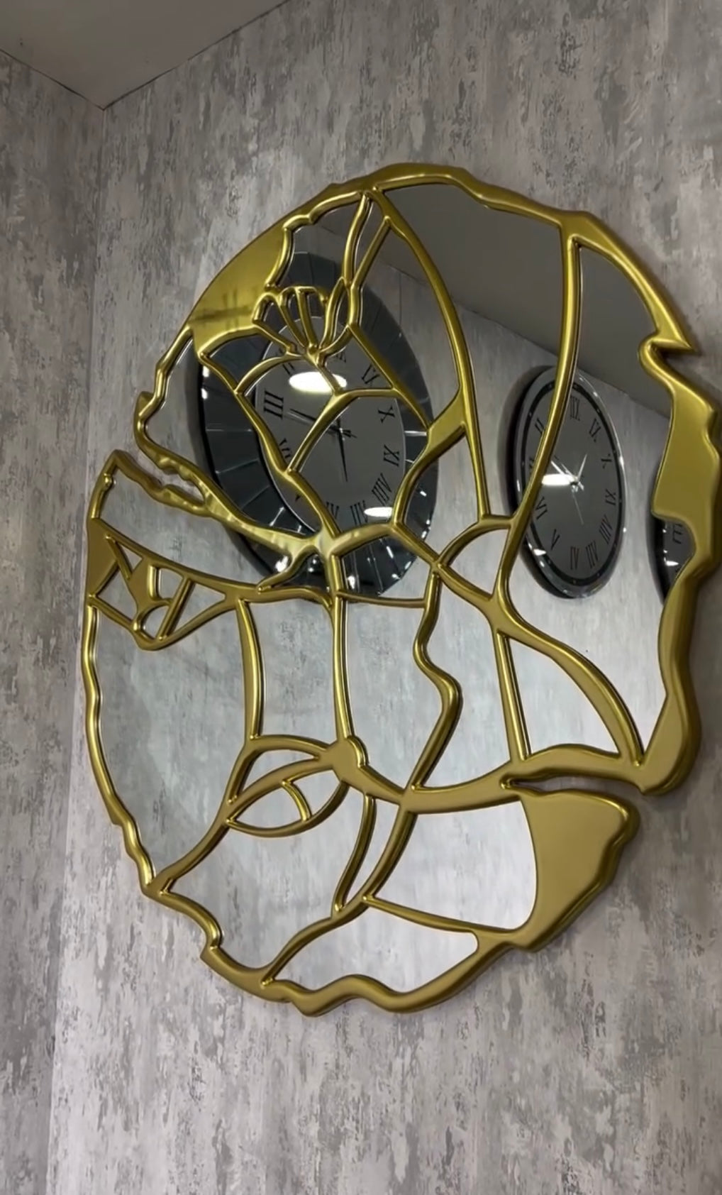 Contemporary gold face-shaped mirror featuring artistic design with floral elements, wall-mounted