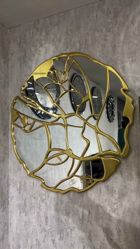 Modern abstract face wall mirror with gold outline frame on textured grey wall decor