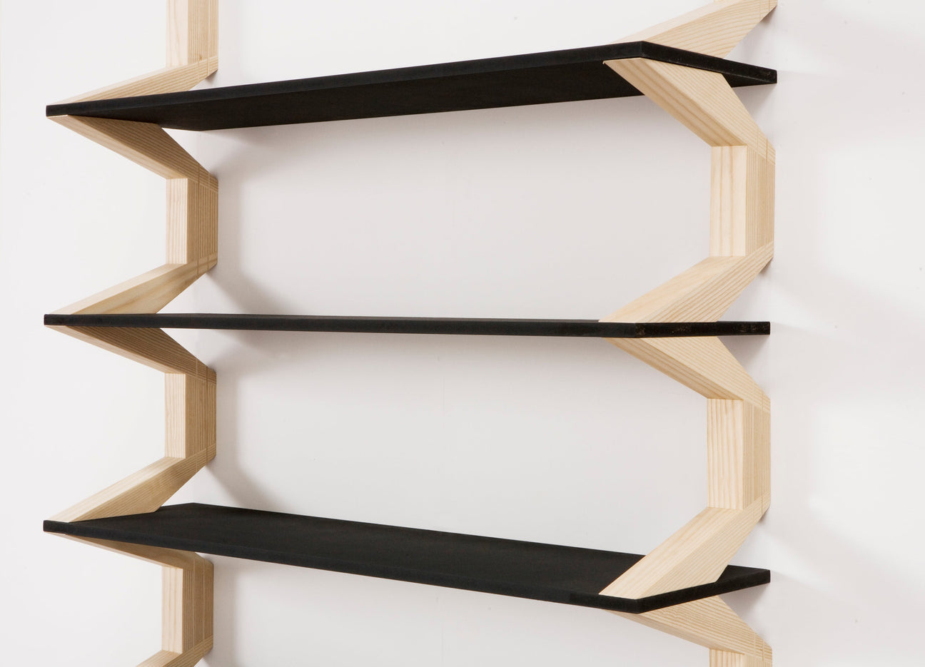 A contemporary shelving unit featuring a sculptural wooden frame, supporting books and decorative pieces.