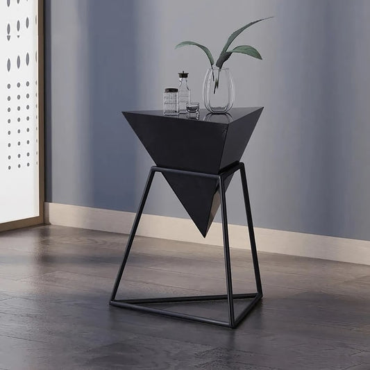 Modern black geometric side table next to cozy cream sofa in a high-rise apartment.