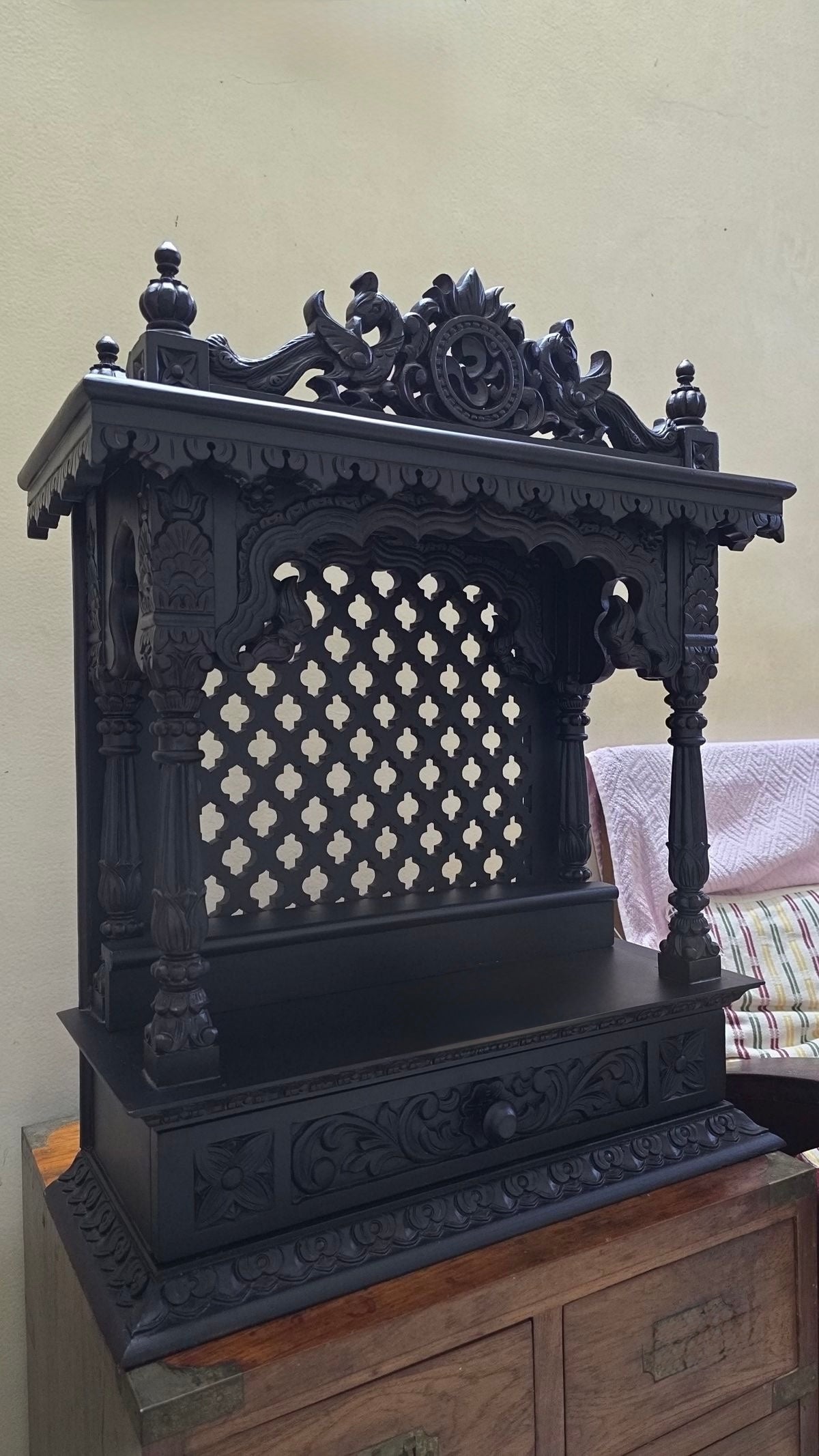 Dark finish teakwood temple with ornate detailing and spiritual design