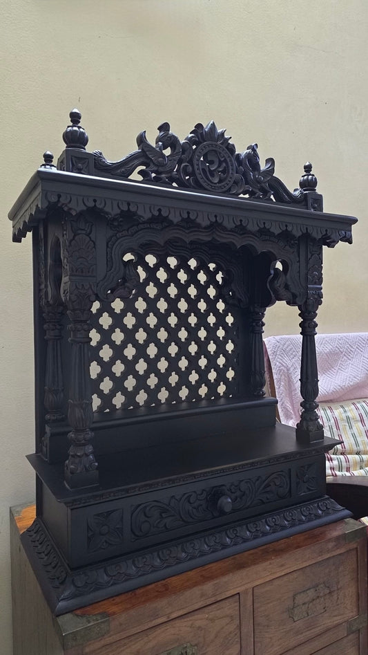 Dark finish teakwood temple with ornate detailing and spiritual design