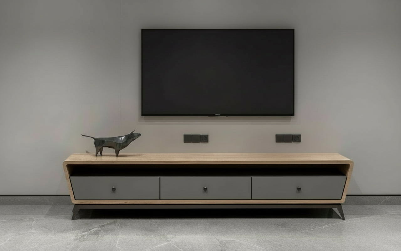Modern wooden TV cabinet with grey drawers placed under wall-mounted TV.