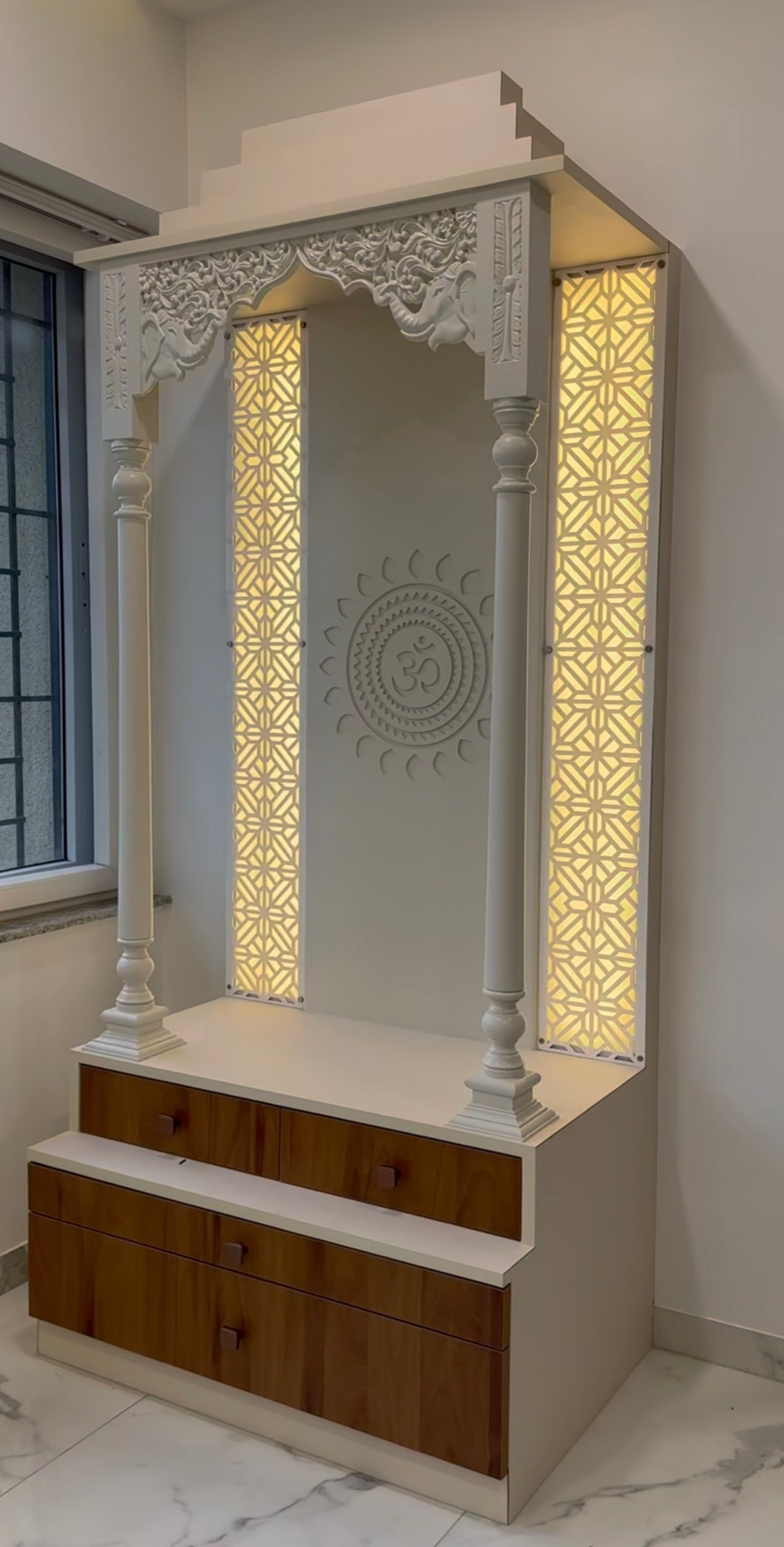 Premium home temple with traditional carving, decorative pillars, and illuminated Om wall design