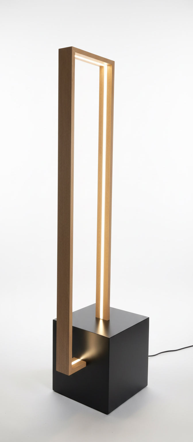 Modern floor lamp with a black base and wooden frame in a workshop setting