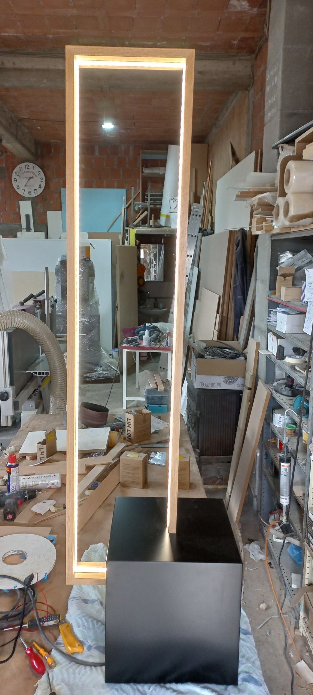 Tall natural wooden floor lamp in a workshop setting